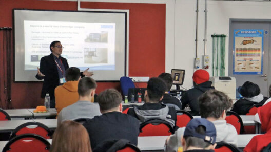 STEM Ambassador Andrea delivering a presentation to a room full of students at Cambridge Regional College