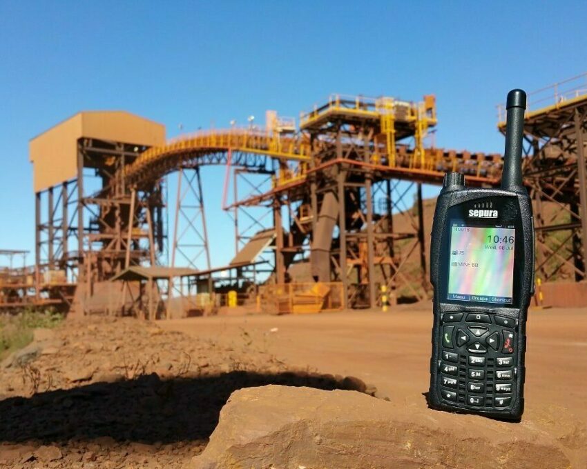 A Sepura SC20 hand portable terminal in front of Australian mining equipment