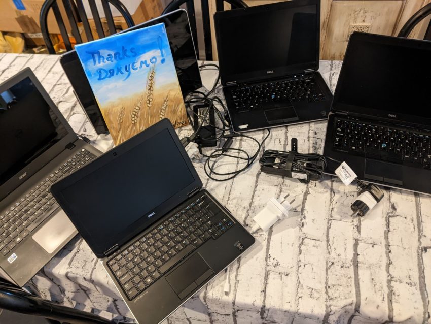 Laptops on a table with a thank you card from a Ukrainian refugee