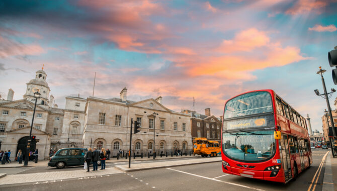 London red bus on streets of London with sunsetting sky in background